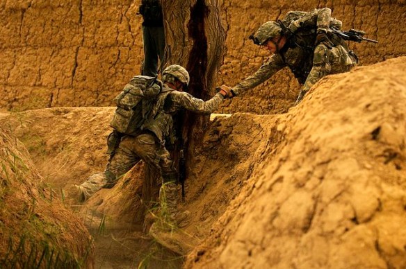 COMBAT OUTPOST MIZAN, Afghanistan—US Army 1st Lt. Troy Peterson, right, platoon commander for 3rd Platoon, Fox Company, 2nd Squadron, 2nd Stryker Cavalry Regiment, assists his radio operator, US Army Pfc. Justin Cobbs, across a ravine during a dismounted patrol near Combat Outpost Mizan, Mizan District, Zabul Province, on Aug. 16, 2010. Photo via the US Army by Senior Airman Nathanael Callon.