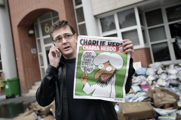 Stéphane Charbonnier, one of today's dead, outside the firebombed office of Charlie Hebdo in 2011.